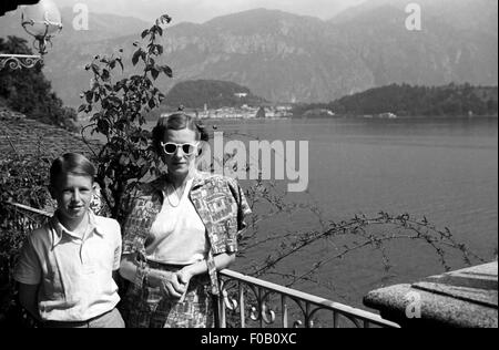 La madre e il figlio in vacanza in piedi da un lago Foto Stock