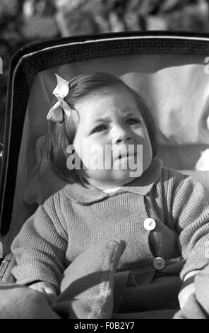 Una bambina seduta in un passeggino. Foto Stock