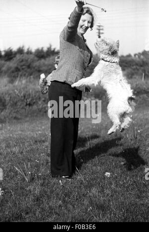 Una donna che gioca con il suo cane Foto Stock