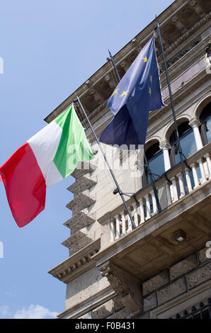 Italiano e bandiere europee battenti bandiera dai poli su palazzo civico Italia Foto Stock