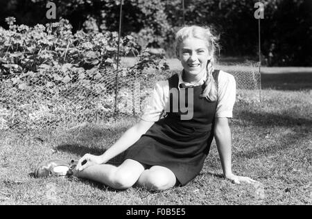 Ritratto di una bionda ragazza dai capelli in un giardino. Foto Stock