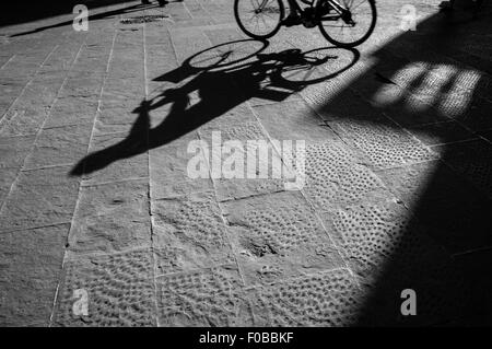 Un uomo in sella per bicicletta in silhouette tramonto Foto Stock