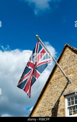 Union Jack flag su una casa a Burford Cotswolds Oxfordshire Inghilterra Uk Europa Foto Stock