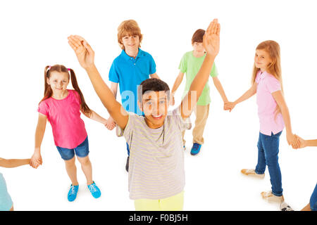 Ragazzo con le mani sollevate stand in un circolo di amici Foto Stock