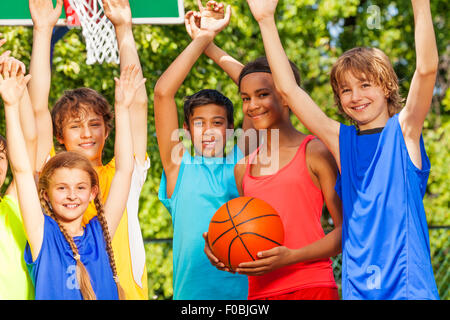 Amici tenere le braccia fino al gioco del basket Foto Stock