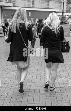 Due turisti bionda passeggiando per Bournemouth shopping centre in chat e camminare insieme. Foto Stock