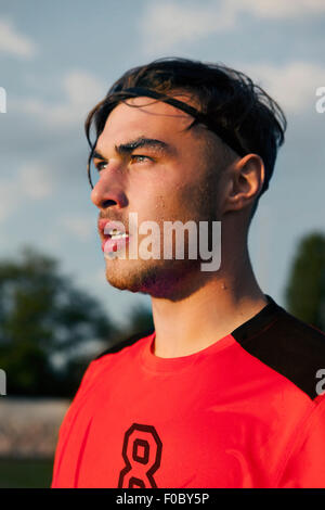 Giovani soccer giocando guardando lontano Foto Stock