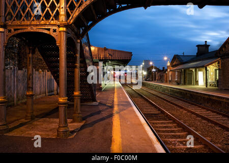 La stazione ferroviaria e il vecchio ponte metallico illuminata di notte, Athenry, Irlanda Foto Stock