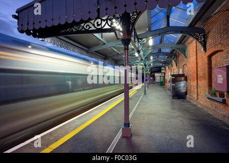 Ad alta velocità ferroviaria intercity in movimento e la stazione di Athenry di notte, Irlanda Foto Stock