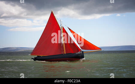 Tradizionali barche di legno Galway Hooker, con il red sail, competere in regata. L'Irlanda. Foto Stock