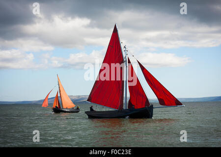 Tradizionali barche di legno Galway Hooker, con il red sail, competere in regata. L'Irlanda. Foto Stock