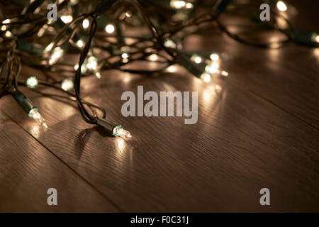 Tradizionali di Natale luci ad albero giacente su un pavimento di legno. Foto Stock