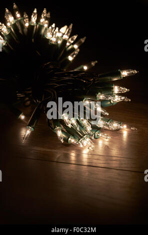 Tradizionali di Natale luci ad albero giacente su un pavimento di legno. Foto Stock