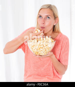 Ritratto di una donna bionda mangiare popcorn Foto Stock