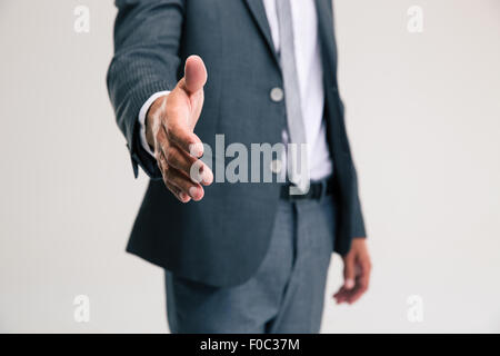 Closeup ritratto di un imprenditore stretching mano per stretta di mano isolata su uno sfondo bianco Foto Stock
