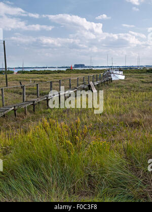 Passerella per la casa galleggiante sul litorale a West Mersea. Mersea Island. Essex. In Inghilterra. Regno Unito. Foto Stock