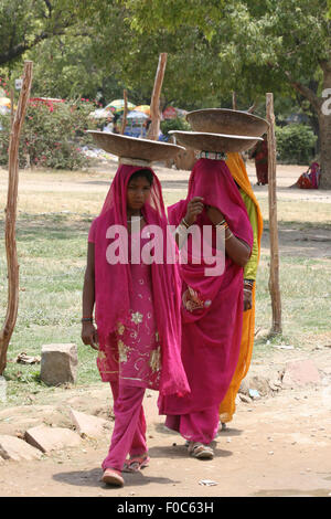 Nuova Delhi - 27 giugno: Sconosciuto le donne indiane in colorati abiti tradizionali che trasportano le cose sulle loro teste a Nuova Delhi, India Foto Stock