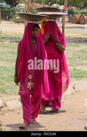 Nuova Delhi - 27 giugno: Sconosciuto le donne indiane in colorati abiti tradizionali che trasportano le cose sulle loro teste a Nuova Delhi, India Foto Stock