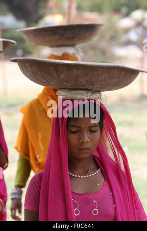 Nuova Delhi - 27 giugno: Sconosciuto le donne indiane in colorati abiti tradizionali che trasportano le cose sulle loro teste a Nuova Delhi, India Foto Stock