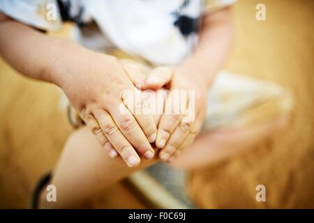 Close up boy tenendo il suo ginocchio con le mani Foto Stock