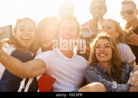 Gruppo di amici prendendo selfie sulla spiaggia Foto Stock