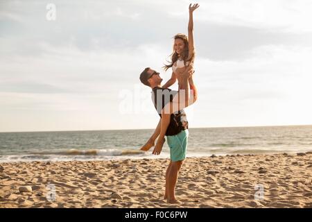 Giovane avendo divertimento sulla spiaggia, Malibu, California, Stati Uniti d'America Foto Stock