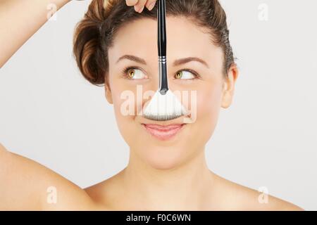 Giovane donna tenendo il make-up spazzola Foto Stock