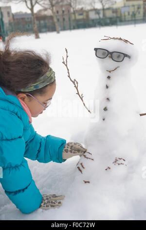 Ragazza giovane edificio pupazzo di neve Foto Stock