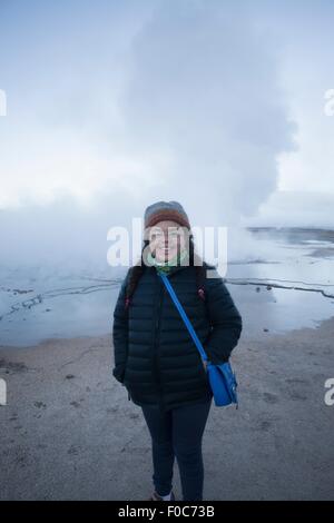 Giovane ragazza in piedi di fronte a Tatio Geyser, sorridente, San Pedro. Atacama. Cile Foto Stock