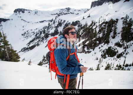 Giovane maschio sciatore guardando fuori dalla montagna, il Monte Baker, Washington, Stati Uniti d'America Foto Stock