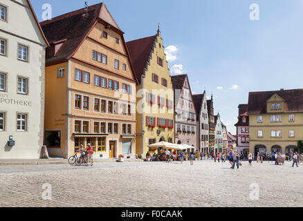 I turisti a piedi da tipici edifici sulla Marktplatz Piazza del Mercato, Rothenburg ob der Tauber, Franconia, Baviera, Germania Foto Stock