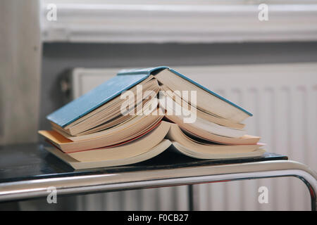 Close-up di una pila di libri aperti sul tavolo Foto Stock