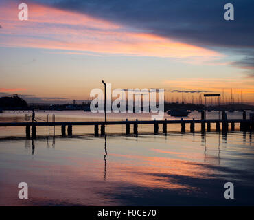 Barche e molo al Belmont lago Macquarie New South Wales NSW Australia al tramonto Foto Stock