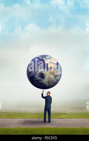 Ambientale il concetto di business imprenditore tenendo la filatura del pianeta terra aloft con un dito Foto Stock