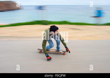 Moto Blured di adolescenti in un longboard andando giù per la collina. Longboard è un tipo di sport eq Foto Stock