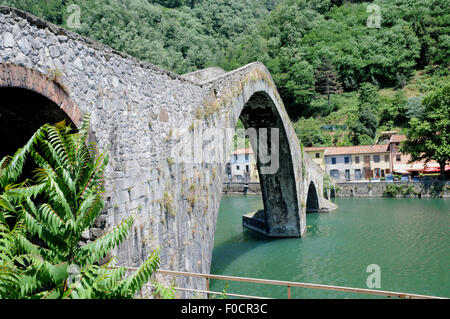 Il medievale Ponte della Madalena o Ponte del Diavolo,oltre il fiume Serchio a Borgo a Mazzano, vicino a Bagni di Lucca, Toscana. Foto Stock