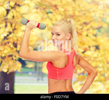 Giovane donna sportivo con luce dumbbell Foto Stock