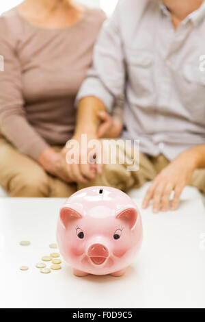 Chiusura del giovane con monete e salvadanaio Foto Stock