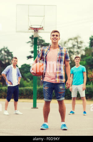 Un gruppo di ragazzi sorridenti giocare a basket Foto Stock