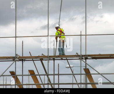 Vista dettagliata del lavoratore edile impalcatura di assemblaggio sul sito di costruzione Foto Stock