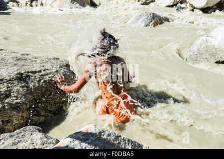 Un Sadhu, uomo santo, è prendere il bagno nell'acqua gelida a Gaumukh, la fonte principale di fiume santo Ganges, Gangotri Foto Stock