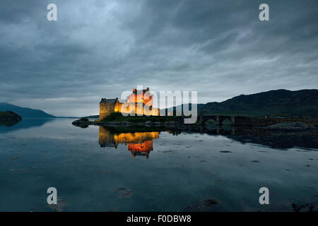 Eilean Donan Castle, sede ancestrale del clan scozzesi di Macrae, riflessione in serata a Loch Duich, Dornie Foto Stock