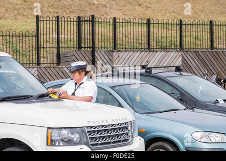 Un vigile che rilascia un biglietto di parcheggio sul lungomare di Southend in Essex. Foto Stock