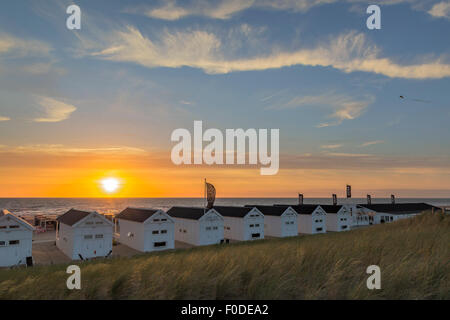 Allineati cottage estivi per noleggio con vista al tramonto sopra il mare del Nord a Katwijk aan Zee, in South Holland, Paesi Bassi. Foto Stock