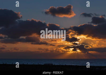 Raggi crepuscolari o raggi del sole sopra il mare del Nord, una sera d'estate, a Katwijk aan Zee, South Holland, Paesi Bassi. Foto Stock