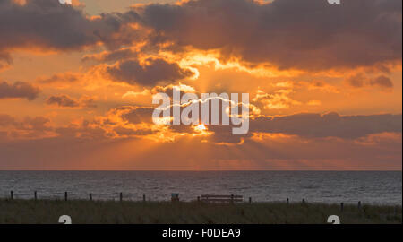 Raggi crepuscolari o raggi del sole sopra il mare del Nord, una sera d'estate, a Katwijk aan Zee, South Holland, Paesi Bassi. Foto Stock