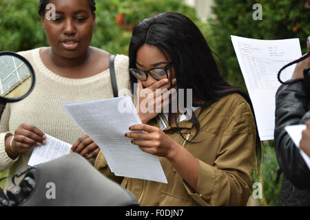 Un nero ragazza adolescente osservando attentamente il suo esame dei risultati a Londra Scuola Secondaria England Regno Unito Foto Stock