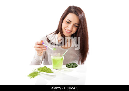 Detox. Bellissima ragazza con verde drink in mano isolato su bianco. Spirulina, clorella e wheatgrass. Uno stile di vita sano, detox. Foto Stock