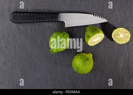 Maturi frutti di bergamotto su sfondo nero, vista dall'alto. Cucina culinaria ingrediente, frutta tropicali bergamotto arancione Foto Stock