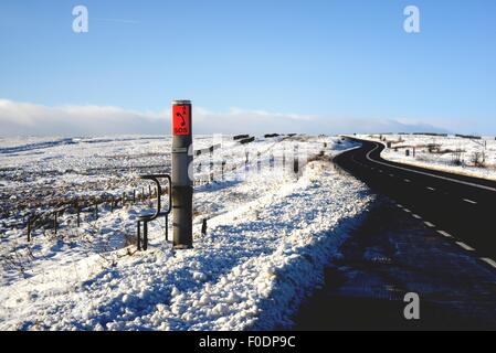 Un punto di SOS con la neve in inverno sul trans Pennine A628 Woodhead pass road in Inghilterra settentrionale. Foto Stock
